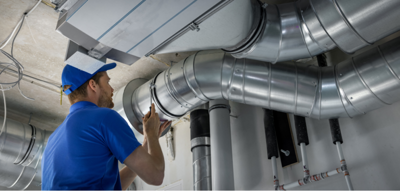 Image of a technician working on an HVAC system