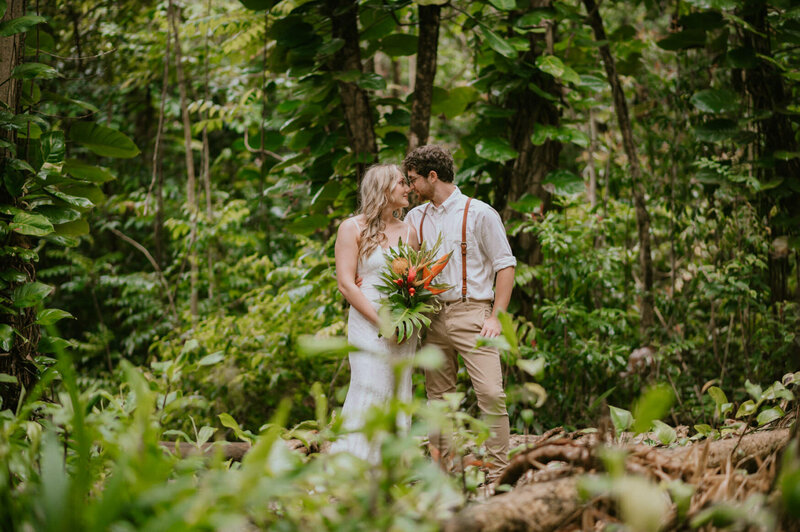 maui hawaii elopement bride and groom looking at each other while surrounded by the rainforest of hana in Maui hawaii