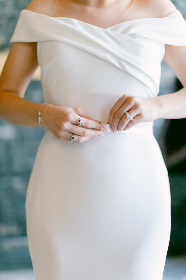 This intimate photograph captures a bride putting on her wedding dress at the Azuridge Butler House. The elegant surroundings provide a serene backdrop as she prepares for one of the most significant moments of her life, filled with anticipation and joy.