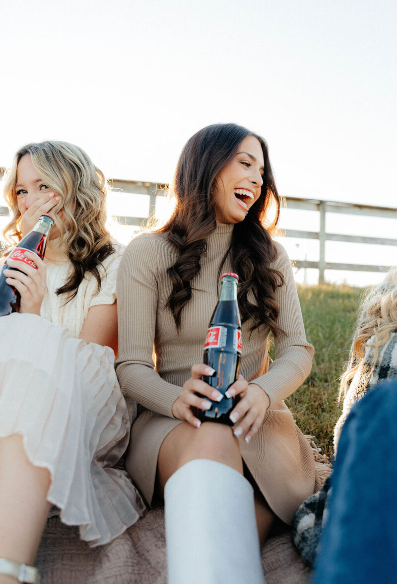 girls laughing with drinks in hand