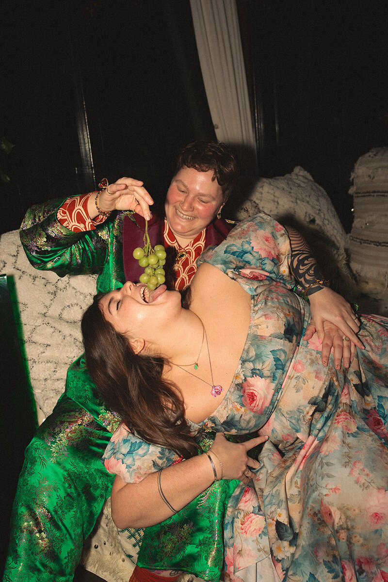 LGBTQ Wedding Couple feeding each other grapes