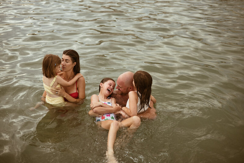 mum and dad play with three children in water