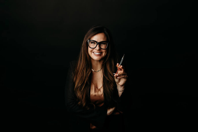 Female nurse smiling with medication in syringes
