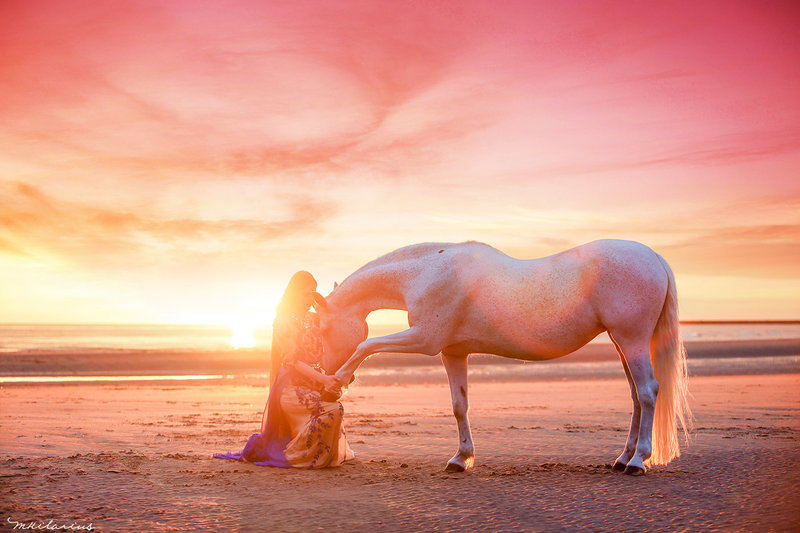 Meisje met pony op strand met zonsondergang
