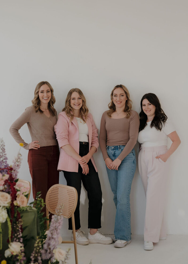 Liz, CJ, &  Molly, Dream Weddings Wisconsin Wedding Planner Team for Dream Weddings, standing around a floral designed table in Milwaukee smiling at the camera.