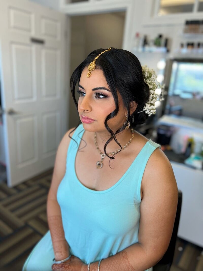 The final touches to an Indian bride's makeup in Ottawa, capturing the essence of bridal beauty.