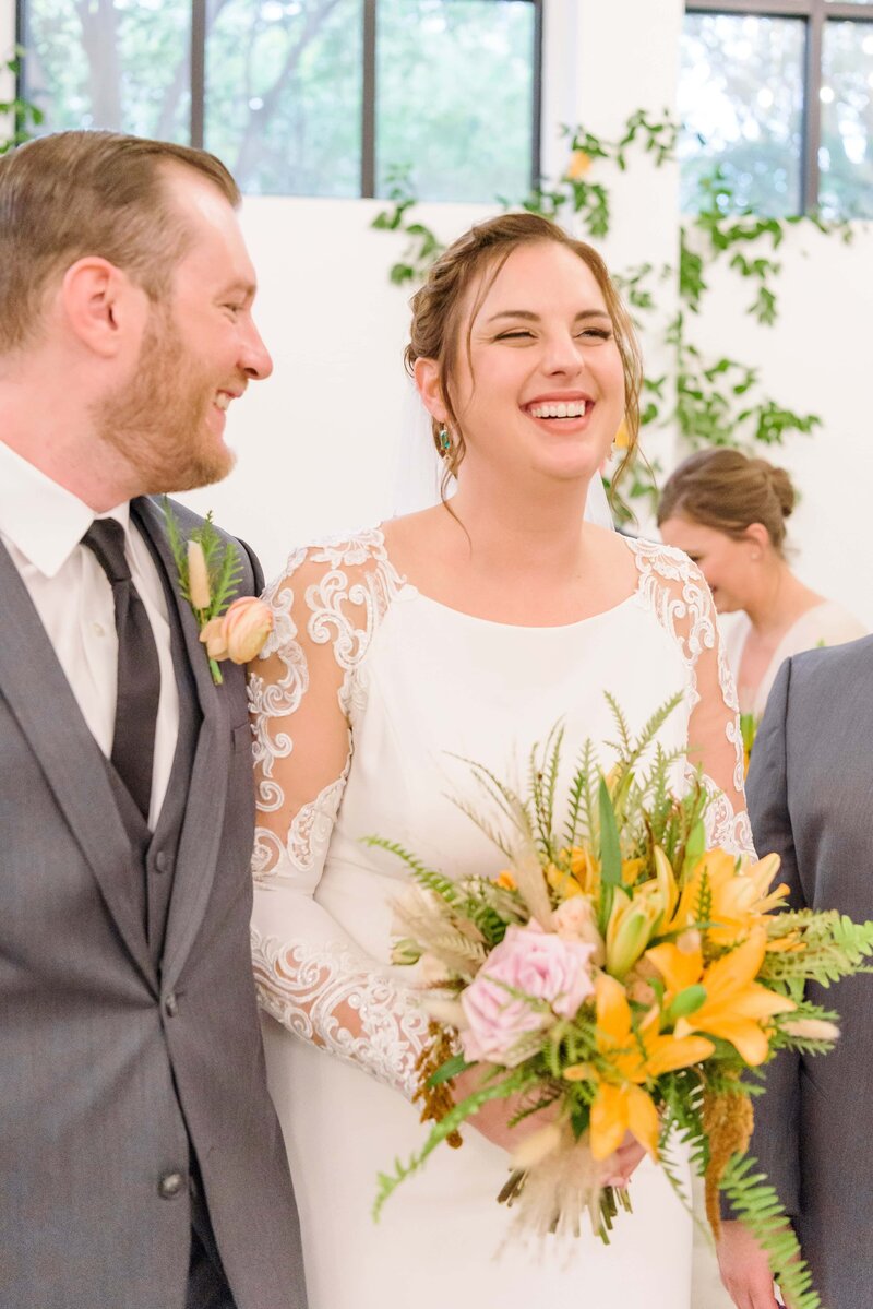 The newlyweds laugh as they walk down the aisle at the Distillery.