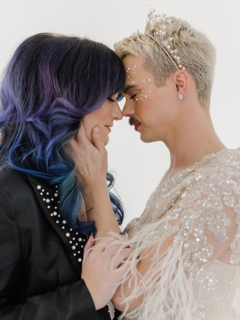 nonbinary wedding couple touching foreheads in intimate embrace