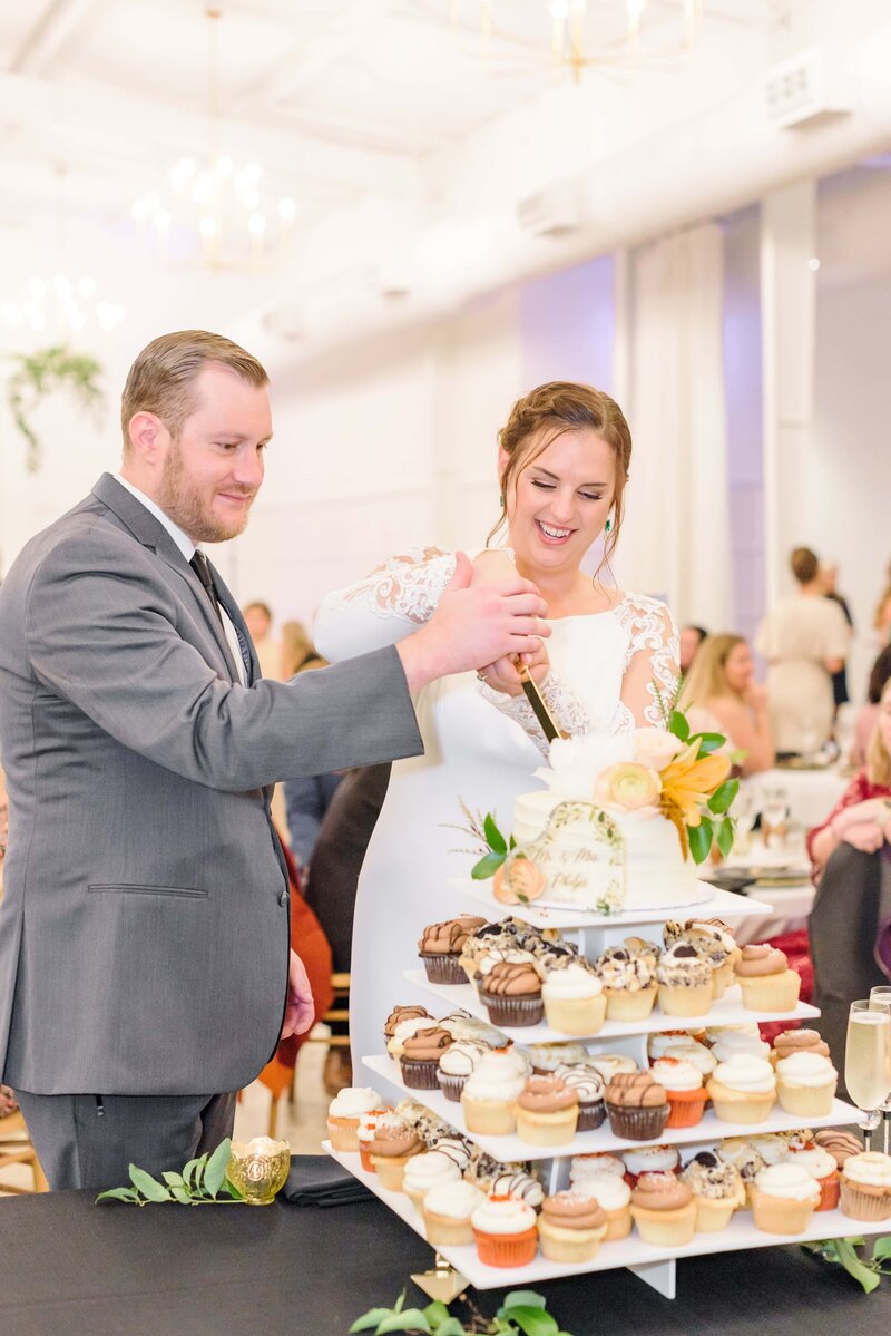 The bride and groom cut their wedding cake at their reception at the Distillery.