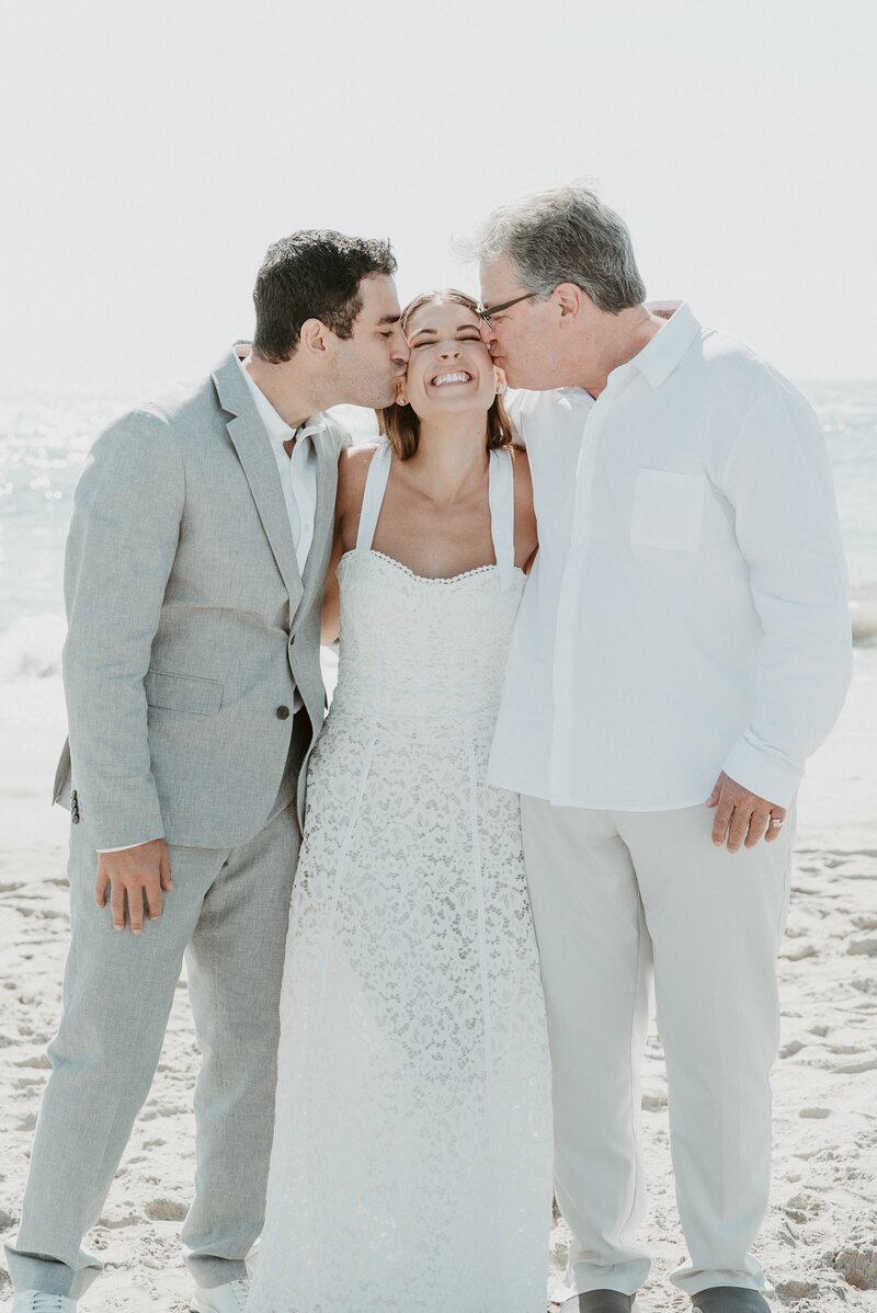 Father and groom kissing bride on cheeks at California micro wedding