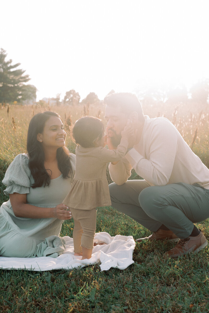 Baby holding dad's face in outdoor family photoshoot in Ottawa