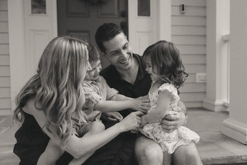 couple holding playful kids during in home family photos captured by NYC family photographer Elsie Goodman 