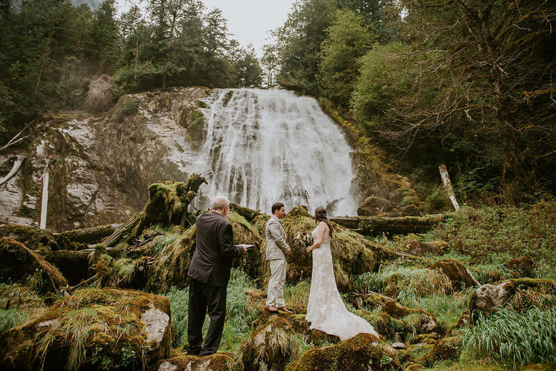 Couple standing under the waterfall during their adventure elopement