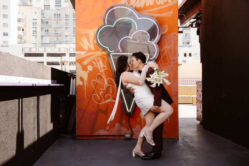 Couple poses in front of neon ice cream sign during Las Vegas Elopement