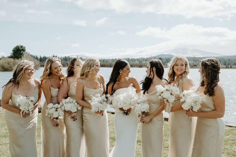 Bride Jenay with bridesmaids holding monochromatic white bouquets, wearing blush dresses at their modern romantic wedding, by Summer Robbins Flowers in Central Oregon