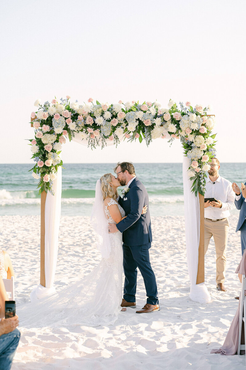 Bride and Groom's first kiss during their wedding ceremony on the beaches of Destin, Florida