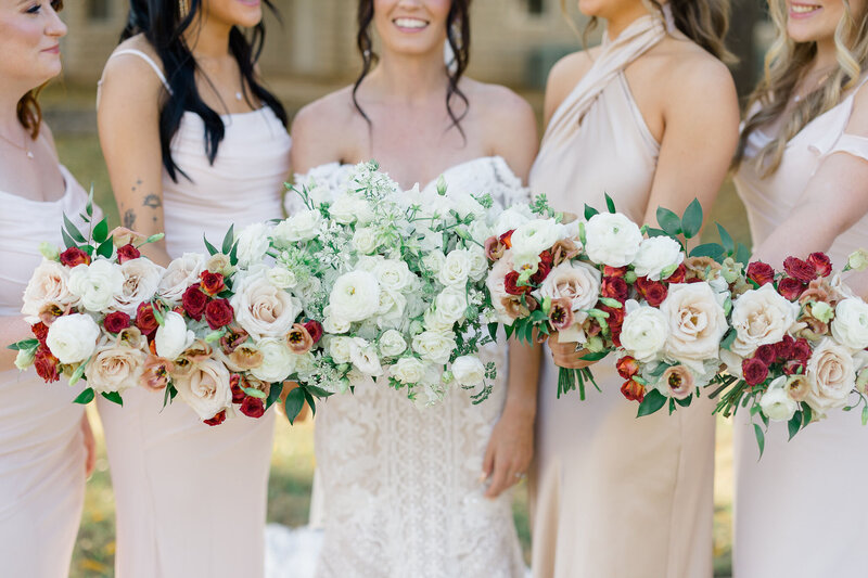 bride with bridesmaids holding their bridal bouquets close together