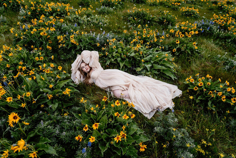 pregnant mama sitting in a field of wildflowers in oregon