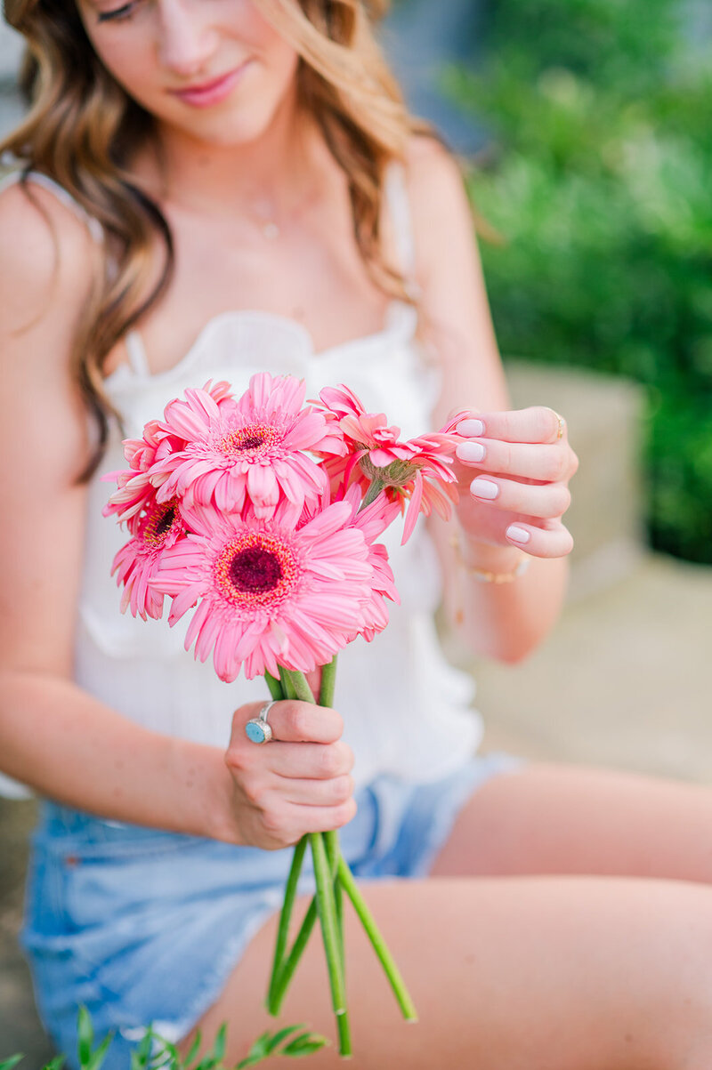 close up of a girl holding pink flowers