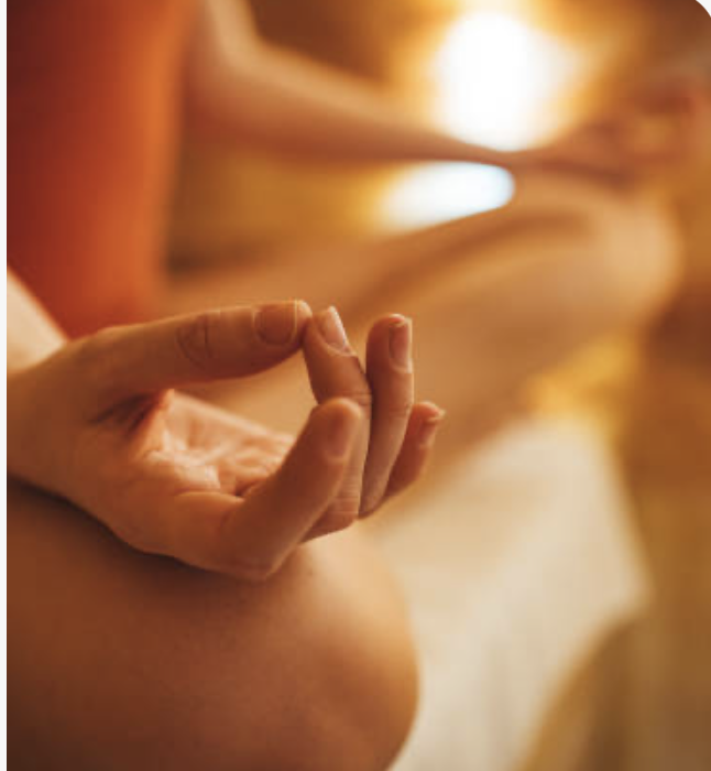 Hands in peaceful meditation position promoting mindfulness and stress relief at Vitalis wellness studio
