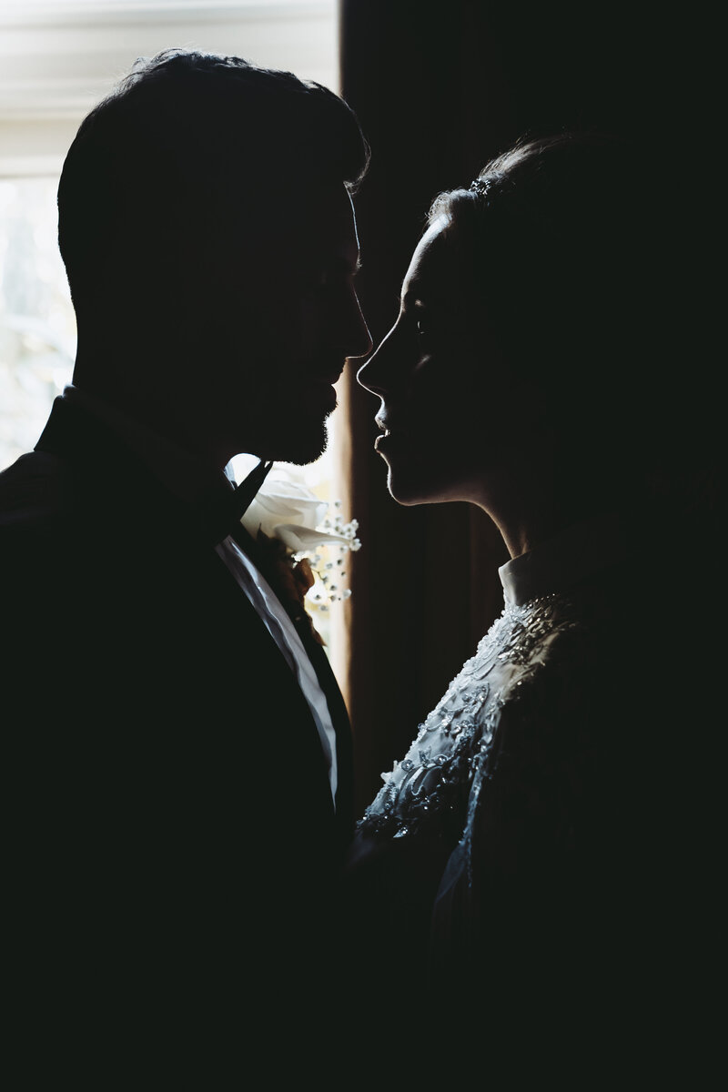 Bride and groom standing close together, gazing into each other's eyes.