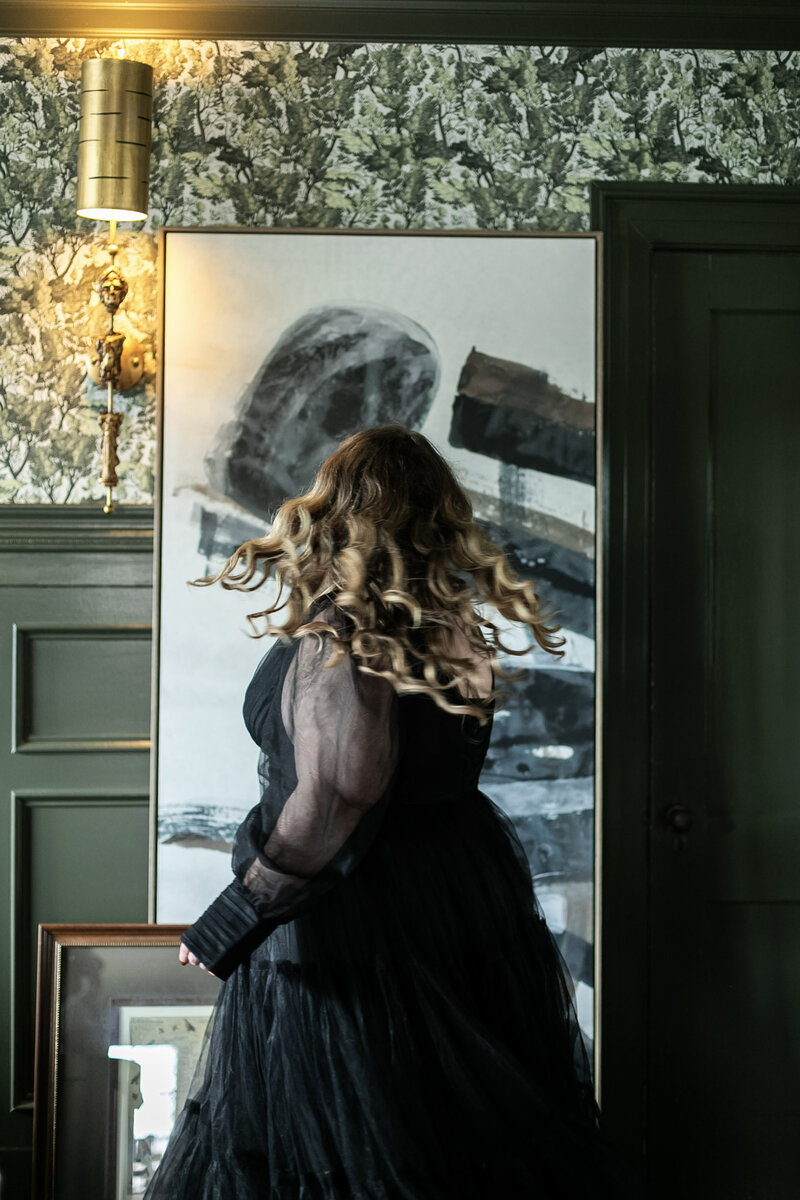 Asheville-based life coach Ashleigh Henry in a black dress, reflecting sacred ambition and softness for high-functioning women entrepreneurs that are holding a lot, over-functioning, and wondering how else they can possibly scale their brands.