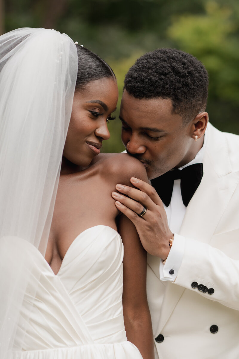 black couple groom kissing bride shoulder wedding