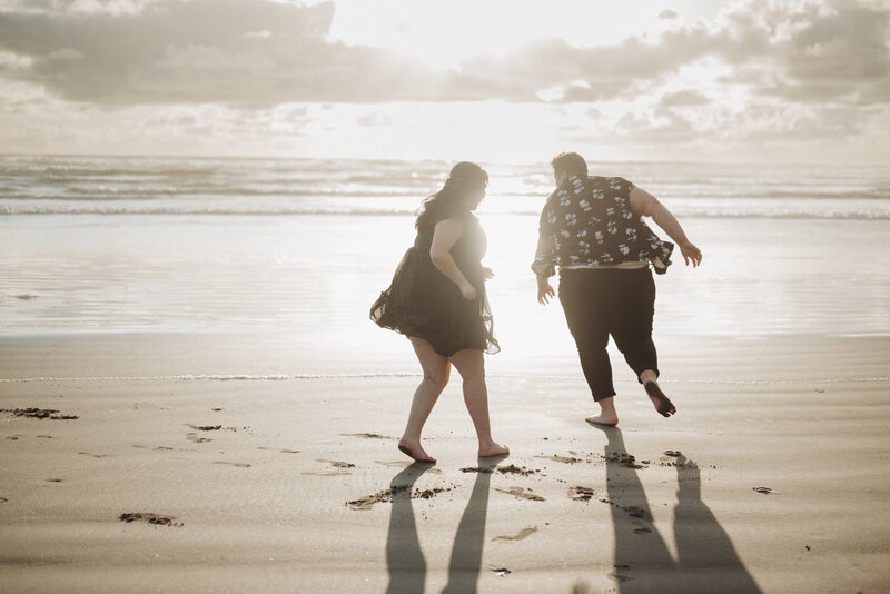 Plus size couple running around the beach in Seaside, Oregon for their engagement photos. 