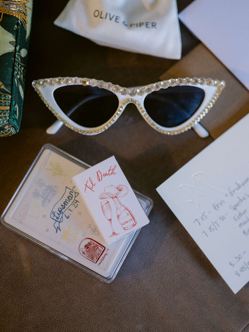 details of a couples wedding with strass sunglasses and stationary