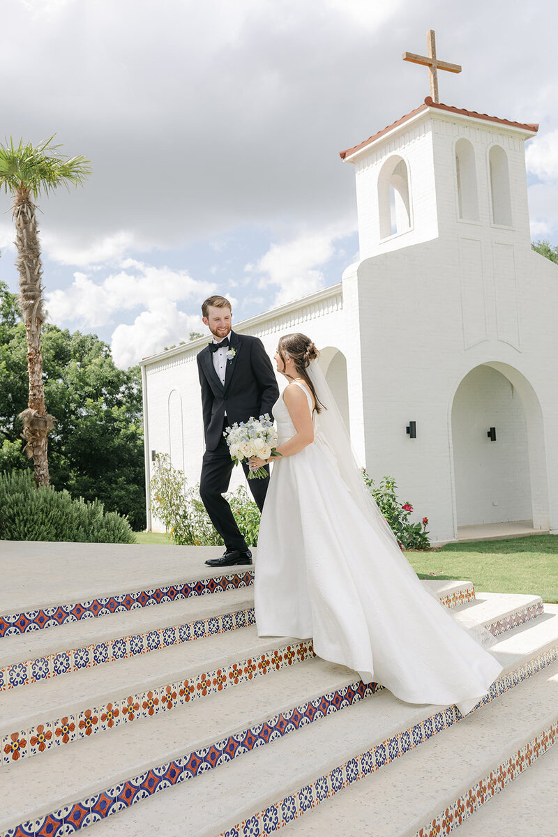 Bride and groom walking hand-in-hand with flowers and joyful expressions