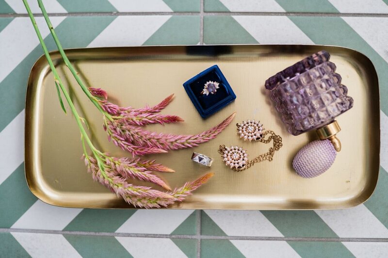 Twizzlers laying on a table next to bottles and flowers.