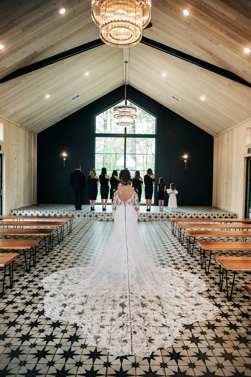 A bride gracefully walks down the aisle at a wedding, captured by an expert Shreveport brand photographer.