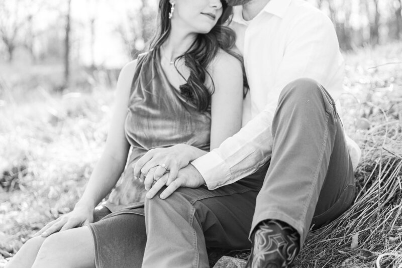 Engaged couple cuddling by a private lake.