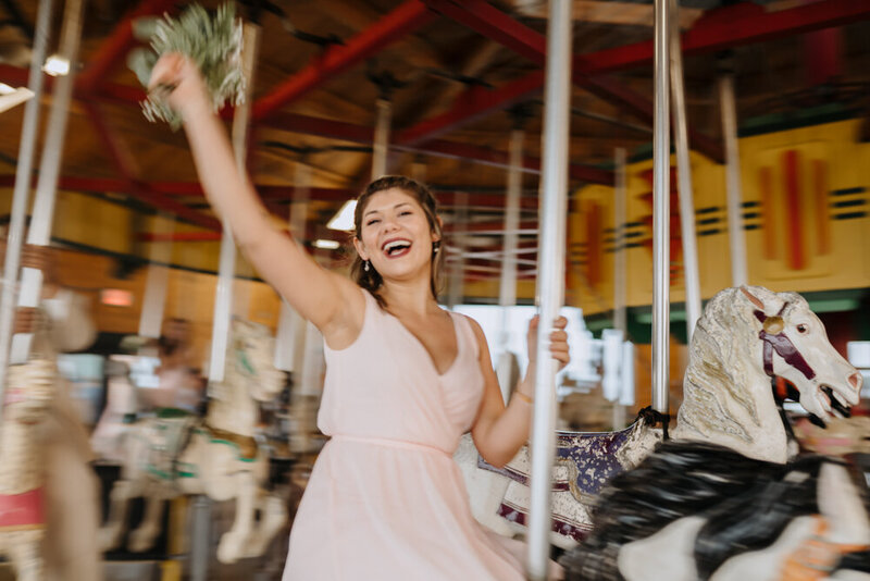 bridesmaid on carnival carousel at wedding reception