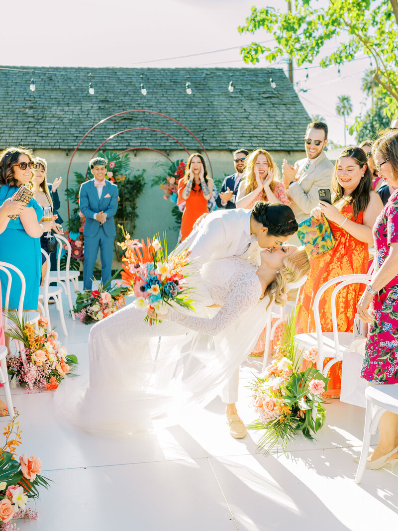 LGBTQ couple kissing at the end of the aisle