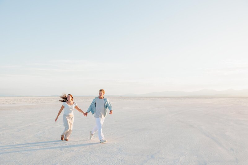 a couple running across the utah salt flats