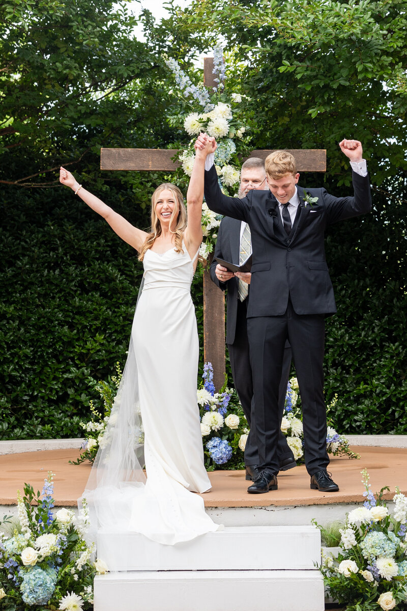 Spring wedding at WinMock at Kinderton, designed by Charming Carolina — bride and groom celebrating as they are announced as husband and wife during the ceremony.