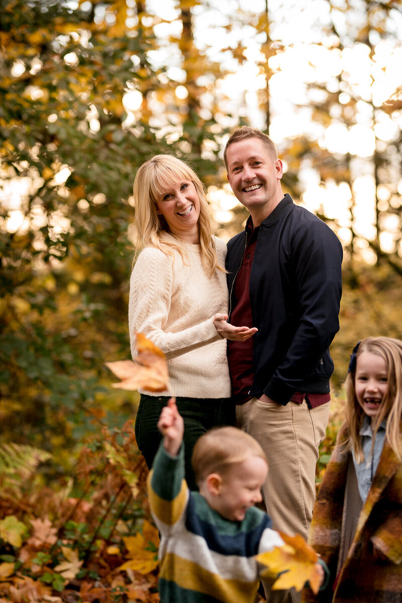 Fall photoshoot session in Redmond, Washington with autumn colors in the backrop. Parents have no hope trying to enjoy a romantic moment while their kids run circles around them - pure joy!