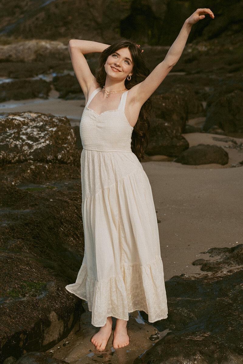 girl in blue floral dress standing on Oregon coast at Heceta Head Lighthouse Beach