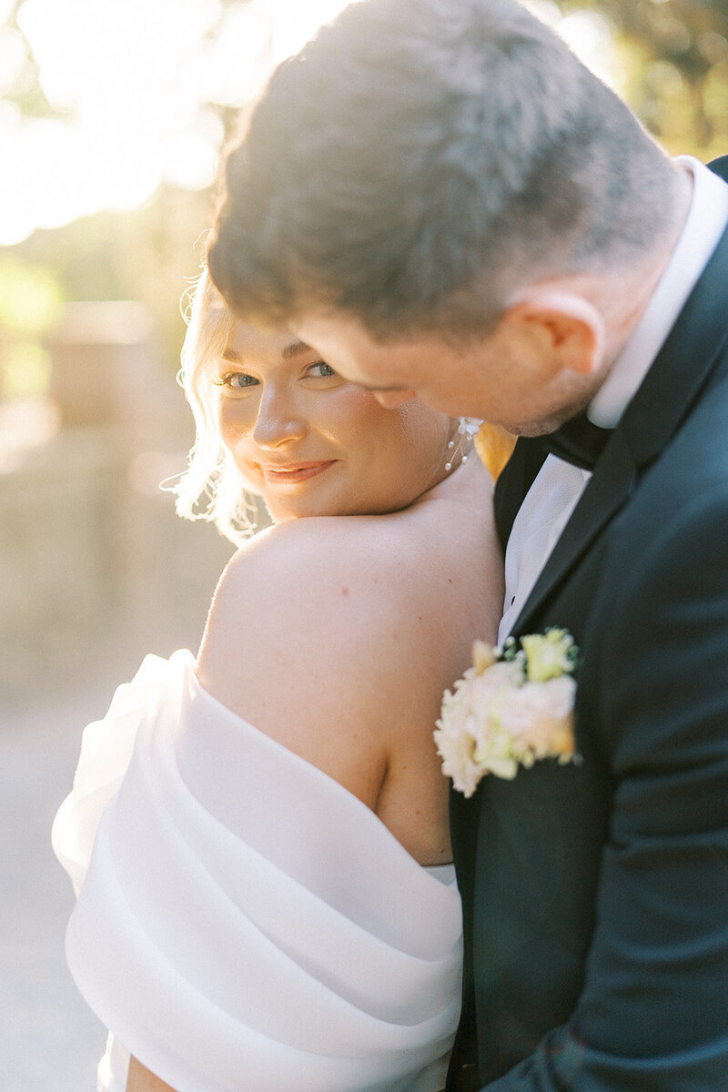 Bride in an off the shoulder gown and groom in a tux wedding portraits in Forest Park in St. Louis