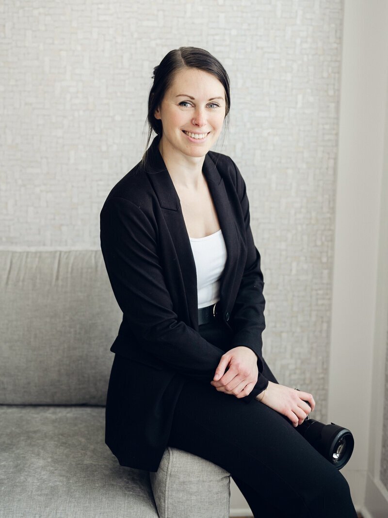 wedding photographer frederick md Nicole Simensky smiling and sitting on couch with camera