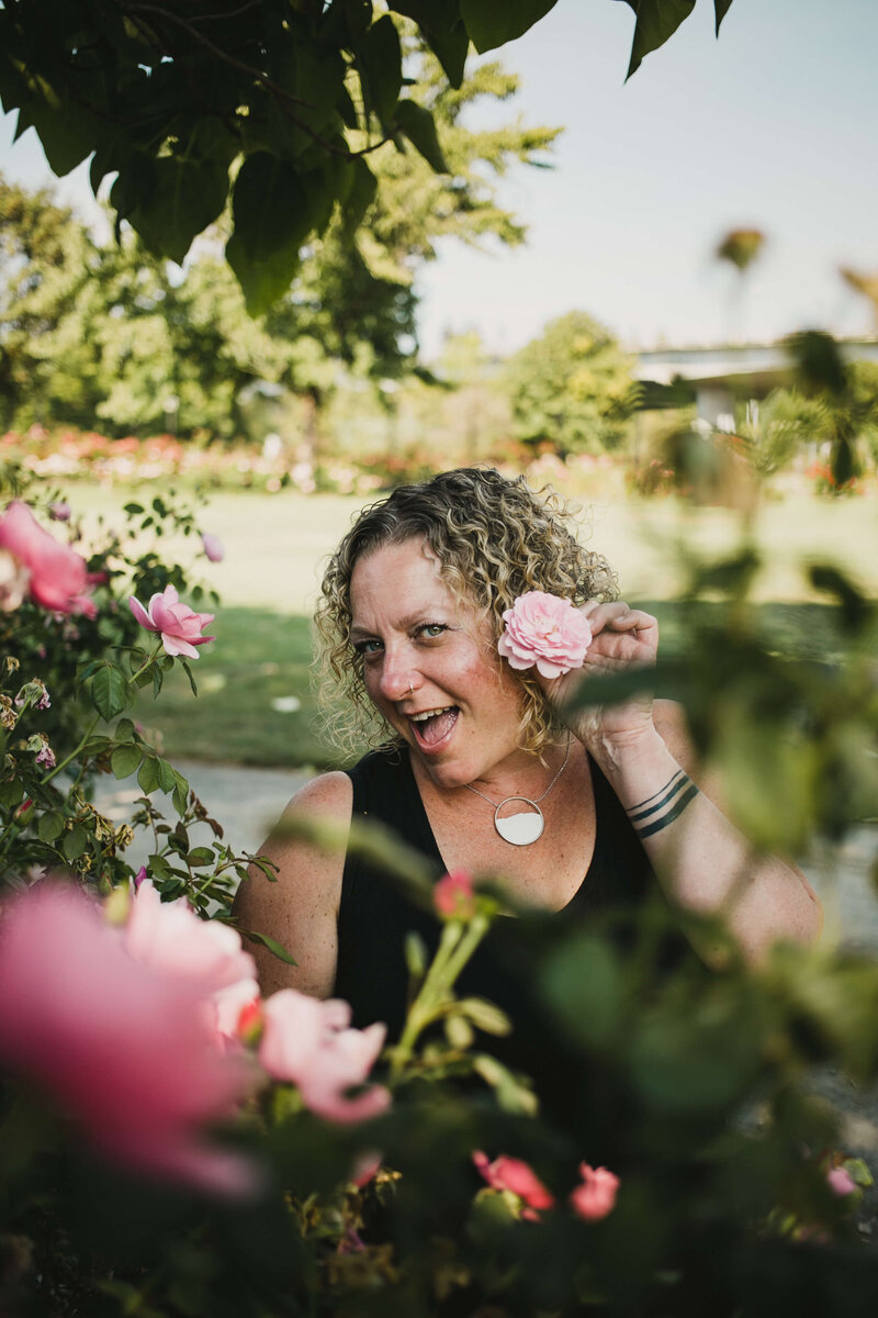 Business attorney, Cassie, holds up a flower by her face representing her love of flowers and working with diverse business owners.