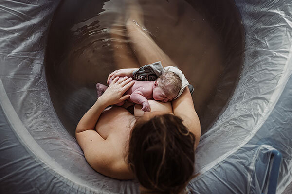 mother with newborn in a birth tub in Portland Oregon