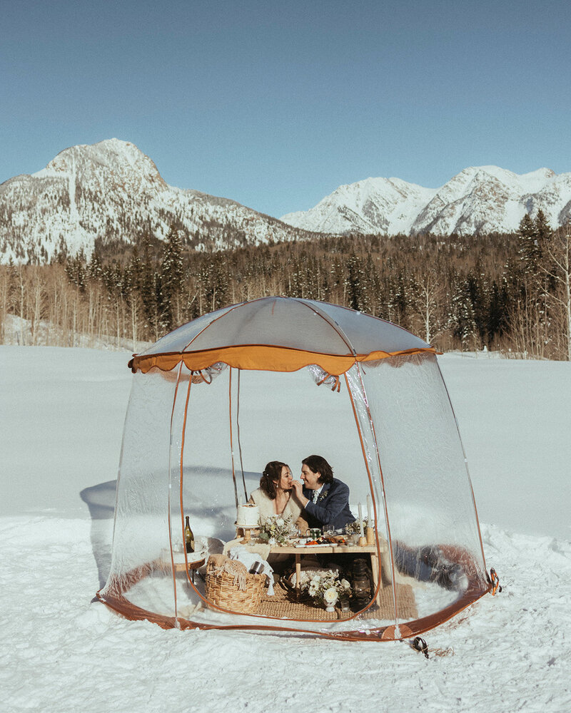 bridge and groom under tent with snow