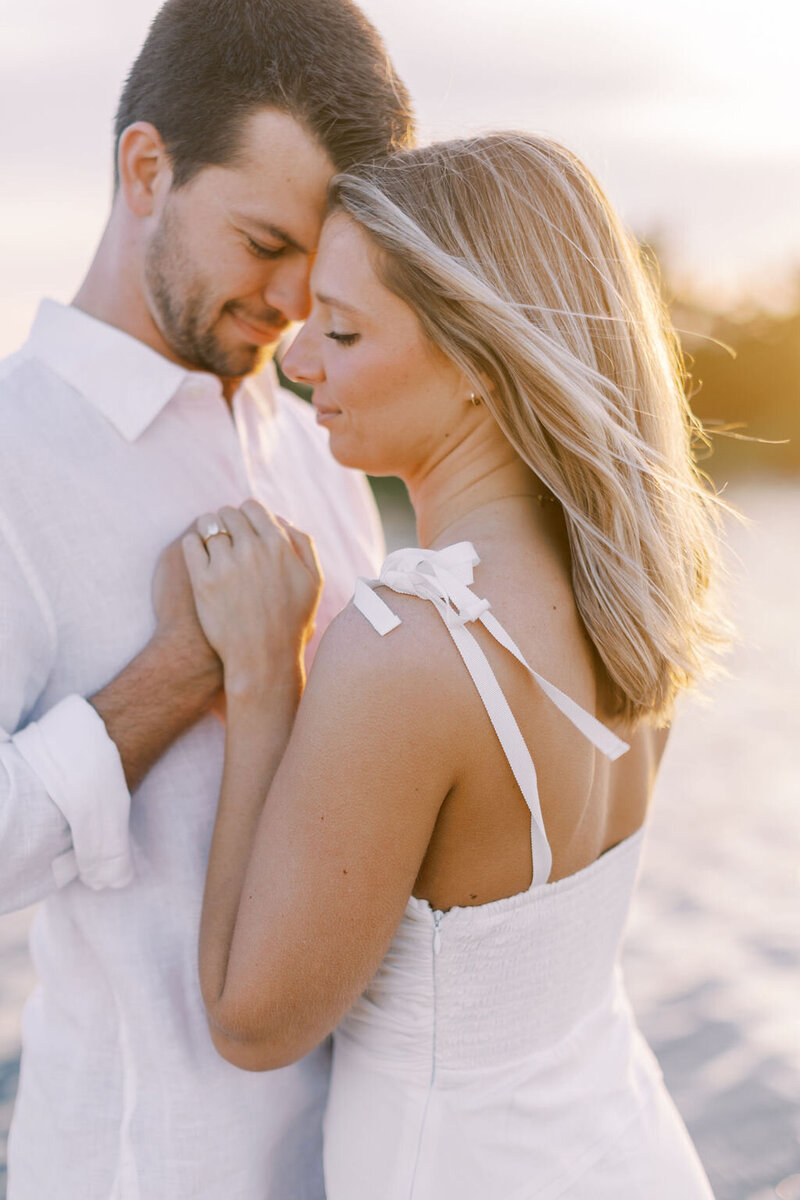 Bride and groom hold hands at sunset