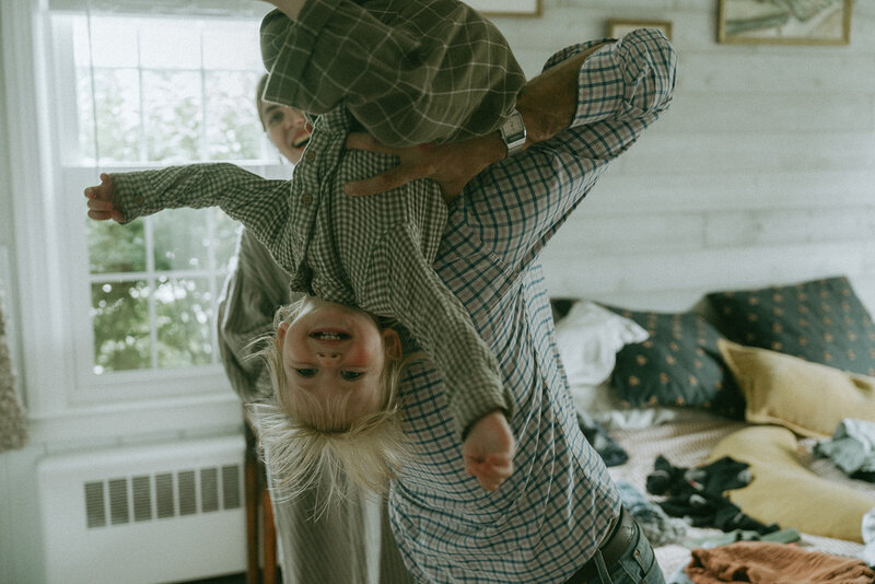 kid held upside down by dad while mom watches, by elsie goodman photography