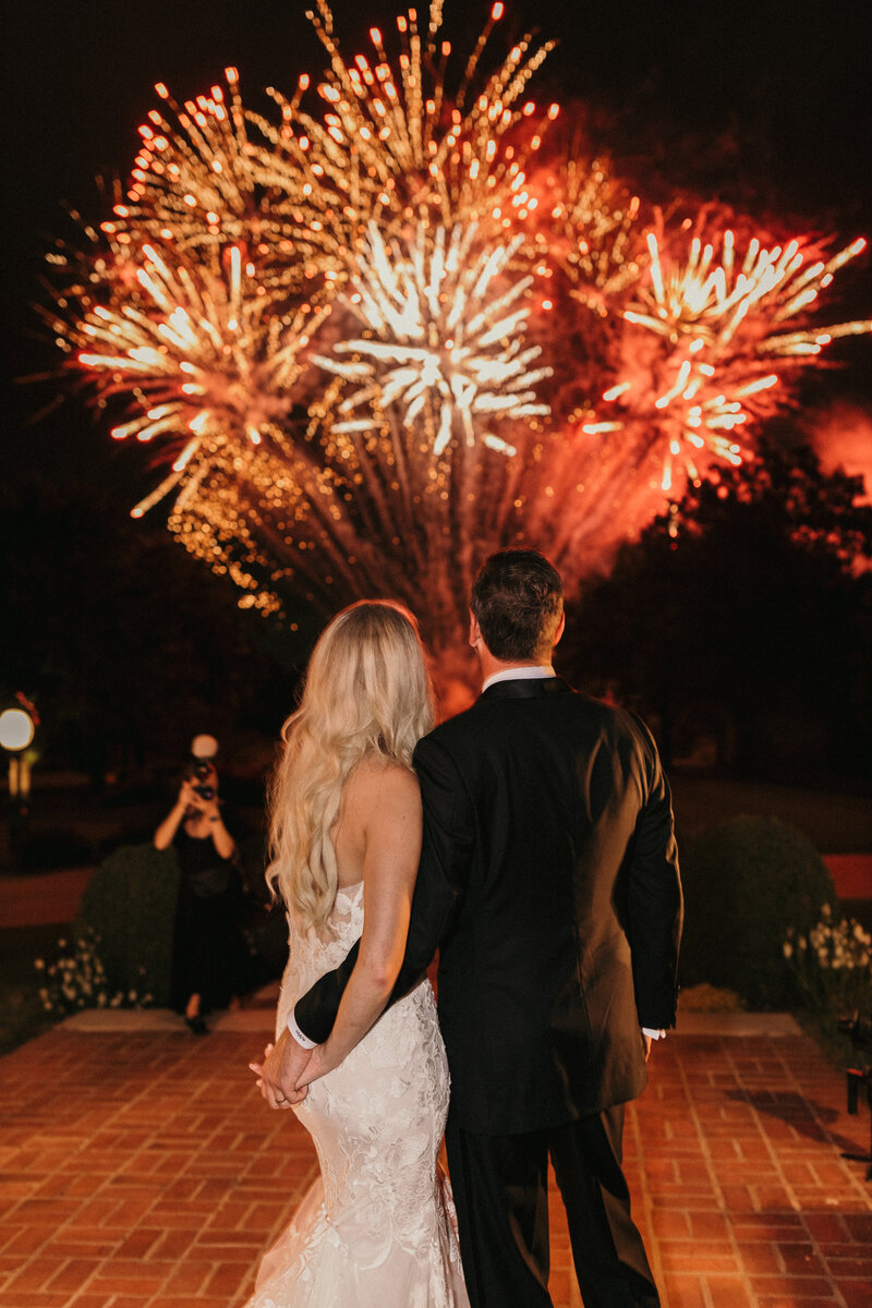 bride and groom watching fireworks at their wedding.