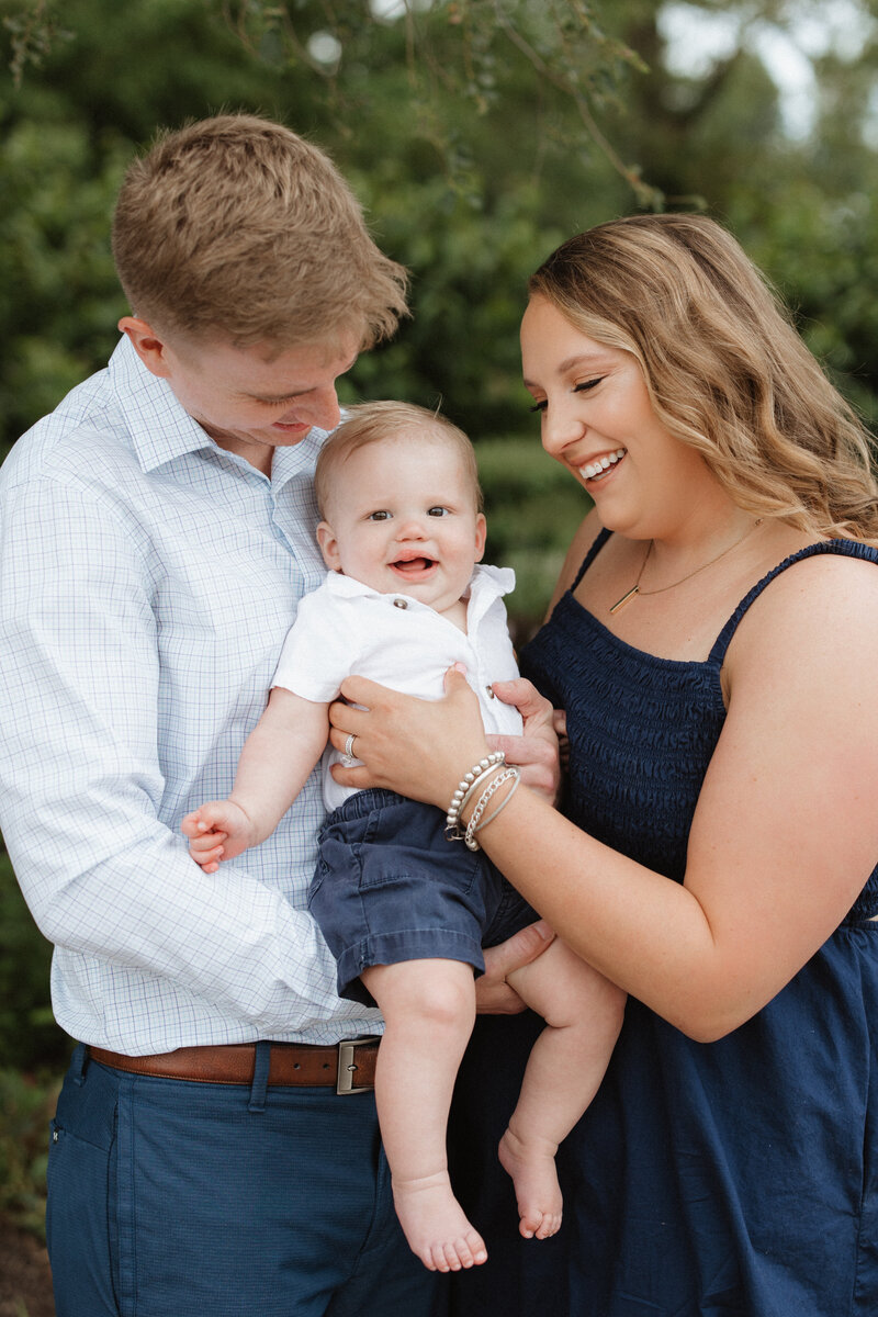 Mother and father looking at toddler son during mini session at Forest Park