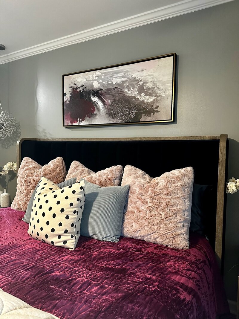 Bed with purple velvety sheets and textured pillows