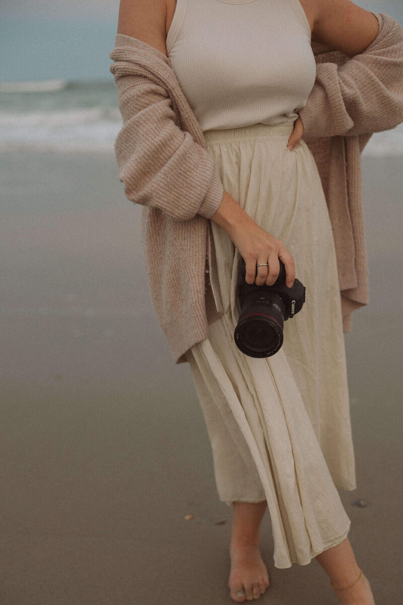 photographer holding camera on emerald isle beach for commercial photography